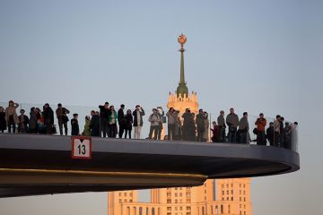 Visitors observe the city and one of the Seven Sisters skyscrapers from the ‘floating bridge’ in Zaryadye park in Moscow, Russia