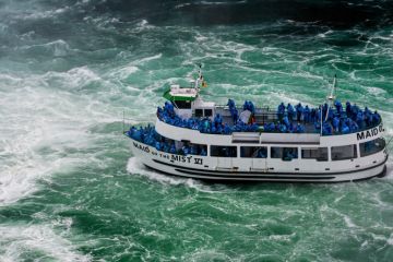 Niagara Falls, NY, USA - June 13, 2019 Ship with tourists moves to Niagara falls, Falls boat tour experience is North America oldest attraction, and has drawn millions of visitors since 1846