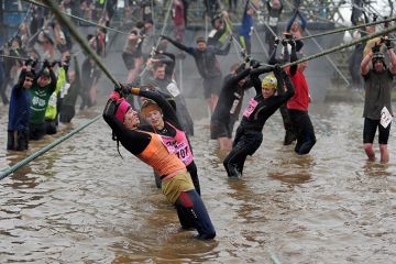 Competitors tackle a rope bridge during the Tough Guy Challenge endurance race. To illustrate that universities are calling “stability” from government policy regarding international students, with the graduate route visa apparently at risk.
