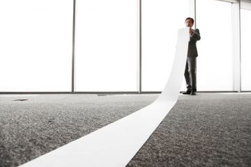 Office worker unrolling long sheet Office worker unrolling long sheet