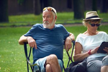 Older couple rest on a park bench Older couple rest on a park bench