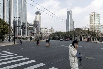 Woman in mask carrying laptop