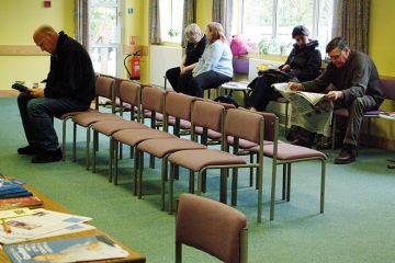 Patients sitting in doctors surgery waiting room
