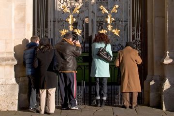 People look though gate to All Souls College, Oxford, to illustrate the university is to review admissions policies and scholarships as part of an institution-wide focus on postgraduate participation