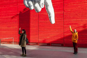 Tourists holding up their fingers, under a giant cartoon finger outside the National Gallery, London, England. To illustrate a government proposal to take a cut of overseas income to pay for HE dismissed as ‘finger in the air" policymaking