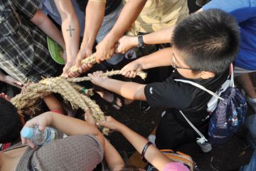 People pulling rope during tug of war festival People pulling rope during tug of war festival