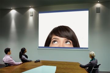 People taking part in Skype call in conference room People taking part in Skype call in conference room