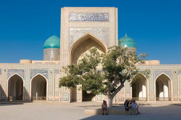 People sitting in the shade of a tree near a mosque, Uzbekistan. To illustrate branch campuses being set up in the country. People sitting in the shade of a tree near a mosque, Uzbekistan. To illustrate branch campuses being set up in the country.