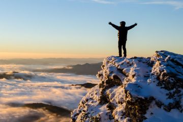 Person celebrating reaching top of mountain Person celebrating reaching top of mountain