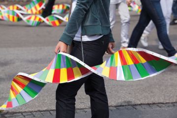 Person in street holding paper replica of DNA strand Person in street holding paper replica of DNA strand