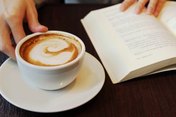 Person reading and drinking coffee Person reading and drinking coffee
