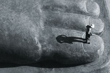 Person standing on big toe of sitting Buddha statue, Leshan Person standing on big toe of sitting Buddha statue, Leshan