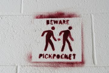 Pickpocket warning sign stencilled on to a white wall to. illustrate I’m being docked pay for boycotting marking – but I teach for free!