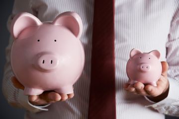 Man holding two piggy banks Man holding two piggy banks
