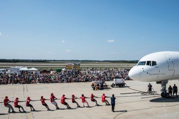 People pull plane on runway