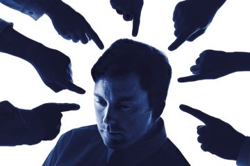 Man surrounding by pointing fingers to illustrate how student evaluations can be detrimental to staff, which could lead to universities facing prosecution. Man surrounding by pointing fingers to illustrate how student evaluations can be detrimental to staff, which could lead to universities facing prosecution.