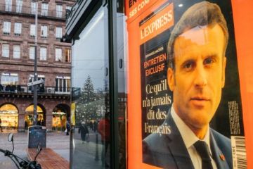 Portrait of French President Emmanuel Macron on the cover of L'Express interview advertising at press kiosk Portrait of French President Emmanuel Macron on the cover of L'Express interview advertising at press kiosk