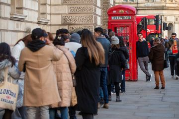 People are seen waiting in a queue for a red phone box in Westminster, London. To illustrate that free speech complaints scheme legislation is unlikely to come to fruition for several years.