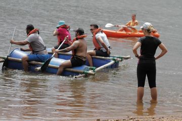 People paddling on a makeshift raft People paddling on a makeshift raft