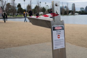 Red tape and warning signs around Albert Park Lake, Melbourne, Victoria, Australia June 06, 2021