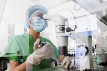 Researcher with microscope in lab