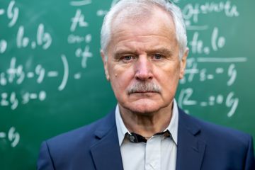 A glum old professor in front of a blackboard A glum old professor in front of a blackboard