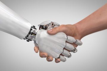 A robot hand shakes a human hand
