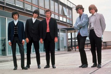 Rolling Stones posing beside airport runway Rolling Stones posing beside airport runway