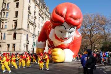 Ronald McDonald balloon hits the ground as it is pulled along Central Park West during the annual Macy's Thanksgiving Day Parade in New York City,