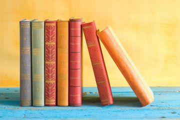 Row of books stacked side-by-side Row of books stacked side-by-side