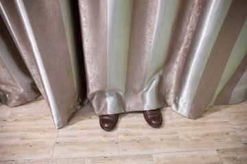 Shoes visible beneath curtain