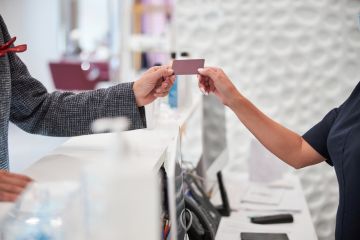 Shop assistant giving the customer a gift card 