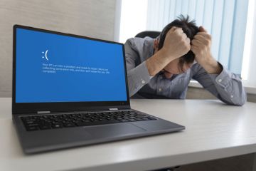 showing error blue screen on the Laptop against the background of an angry upset man clutching his head showing error blue screen on the Laptop against the background of an angry upset man clutching his head