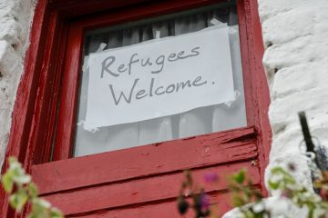 Sign on a window saying Refugees Welcome