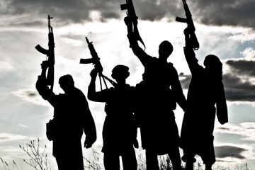Silhouettes of Islamic terrorists aiming guns at sky