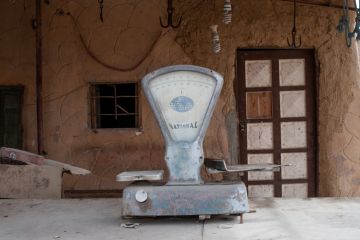 Dusty set of scales outside a closed shop in Siwa, Egypt, 2018 Dusty set of scales outside a closed shop in Siwa, Egypt, 2018
