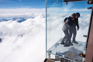 People standing on a glass viewing platform People standing on a glass viewing platform