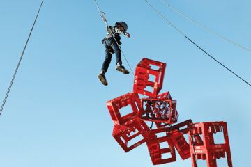 Boy hangs above collapsing crates Boy hangs above collapsing crates