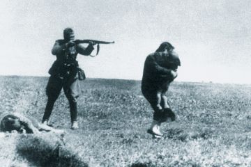 Soldier firing gun at woman and child, World War Two