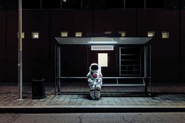 An astronaut sits at a bus stop An astronaut sits at a bus stop to illustrate being left behind