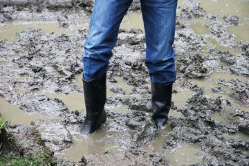 Man wearing boots stuck in the mud Man wearing boots stuck in the mud