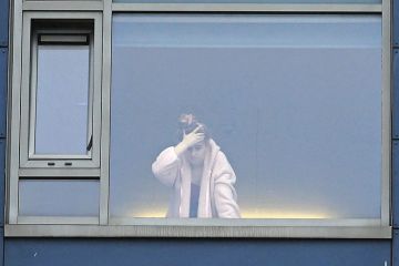A student at the window in a university halls of residence A student at the window in a university halls of residence
