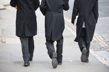 Suited Etonian men walking on street, Eton College, England Suited Etonian men walking on street, Eton College, England