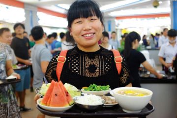 Sun Yat-sen University student holding tray of food