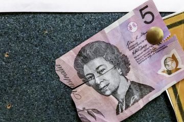 Sydney, Australia - August 1, 2016 A torn half of an Australian five dollar polymer note pinned to a noticeboard. Note features the portrait of Queen Elizabeth II. Sydney, Australia - August 1, 2016 A torn half of an Australian five dollar polymer note pinned to a noticeboard. Note features the portrait of Queen Elizabeth II.