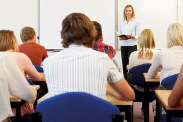 Teacher speaking at front of classroom Teacher speaking at front of classroom