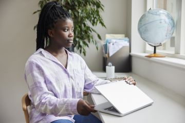 Teenage Girl Closing Lid Of Laptop