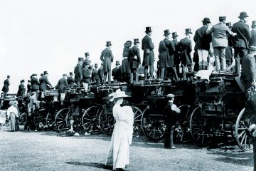 Woman standing behind men on coaches