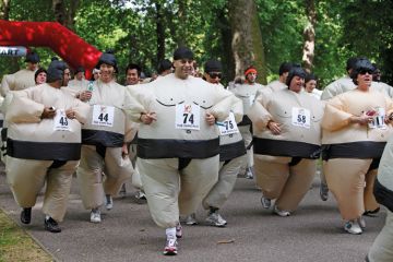 Men and women compete in the quirky annual Sumo Run held on a weekend in June, in Battersea Park, in London, England
