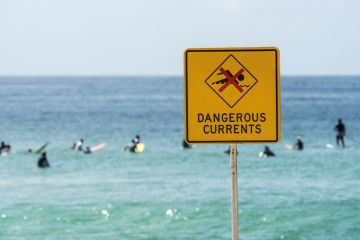 Dangerous currents warning sign on beach, Australia Dangerous currents warning sign on beach, Australia
